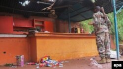 Un soldat malien inspecte les lieux après une attaque terroriste à Sevare, Mali, le 11 août 2015.