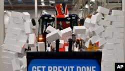 Britain's Prime Minister Boris Johnson drives a JCB through a symbolic wall with the Conservative Party slogan 'Get Brexit Done' in the digger bucket, during an election campaign event at the JCB manufacturing facility in Uttoxeter, England.