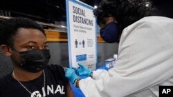 A nurse injects a man with a dose of the Moderna COVID-19 vaccine at an open vaccination site at Jackson State University in Jackson, Miss., Aug. 3, 2021.