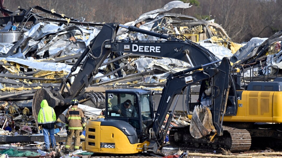 Para petugas penyelamat memberesi puing-puing dari bangunan pabrik lilin Mayfield Consumer Products di Mayfield, Kentucky, pada 11 Desember 2021, setelah tornado hebat melanda wilayah tersebut. (Foto: AP/Timothy D. Easley)