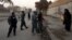 A woman talks to Afghan policemen to allow her to pass as they stand guard near the site of a suicide attack that wounded Afghanistan's spy chief in Kabul, Dec. 6, 2012.