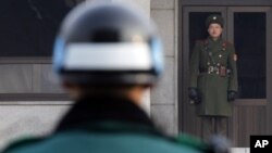 Severnokorejski (desno) i južnokorejski vojnik gledaju jedan u drugog sa dve strane demilitarizovane zone koja razdvaja dve zemlje od završetka Korejskog rata 1953.