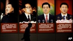 역대 중국 지도자 사진이 걸려있는 베이징의 한 박물관 외벽 앞으로 방문객이 지나가고 있다. 왼쪽부터 덩샤오핑 전 중앙 군사위원회 주석과 장쩌민, 후진타오 전 국가주석, 그리고 시진핑 국가주석.