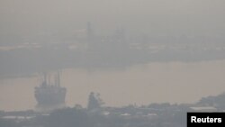 FILE - A cargo ship is seen through air pollution along the Chao Phraya river in Bangkok, Thailand, Jan. 11, 2019. 