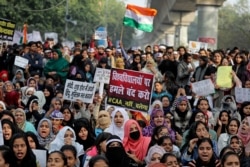 Indian students of the Jamia Millia Islamia University and locals participate in a protest against a new citizenship law, in New Delhi, India, Dec. 21, 2019.