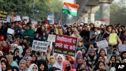 Indian students of the Jamia Millia Islamia University and locals participate in a protest against a new citizenship law, in New Delhi, India, Dec. 21, 2019.