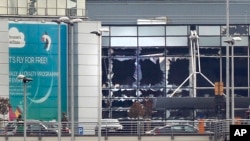 FILE - Broken windows are seen at the scene of explosions at the Brussels airport, Belgium, March 22, 2016. 