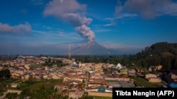 Gunung Sinabung menyemburkan awan panas dan asap ke udara tampak dari Karo, Sumatra Utara, 10 Mei 2021. (Foto: Tibta Nangin/AFP)