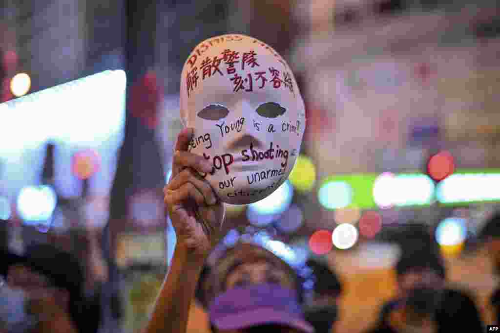 在香港旺角警局外，一名女子手持写着&quot;解散警队 刻不容缓&ldquo;的面具参加示威活动 (2019年10月5日)