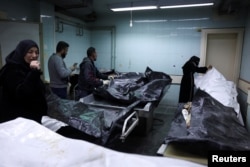 People look at bodies, believed to be of prisoners from Sednaya prison, according to forensic official Zaher al-Taqesh, at the Al Mojtahed hospital, after rebels seized the capital and ousted Syria's Bashar al-Assad, in Damascus, Syria, Dec. 10, 2024.