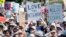 FILE - People hold up signs and shout while listening to speakers during a rally against hate in Berkeley, Calif., Sunday, Aug. 27, 2017.