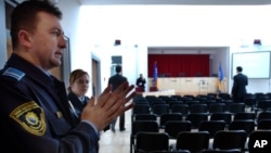 FILE - Security workers do a last inspection of the War Crimes Court room before the inauguration ceremony of the Bosnian War Crimes Court, in Sarajevo, March 9, 2005. 