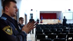 FILE - Security workers do a last inspection of the War Crimes Court room before the inauguration ceremony of the Bosnian War Crimes Court, in Sarajevo, March 9, 2005. 