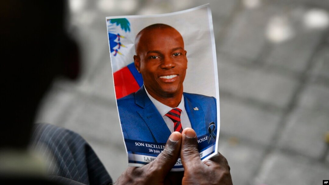 FILE - A person holds a photo of late Haitian President Jovenel Moise during his memorial ceremony at the National Pantheon Museum in Port-au-Prince, Haiti, July 20, 2021. 