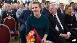 Russian celebrity TV host Ksenia Sobchak, who wants to challenge Russian President Vladimir Putin in the March 18 presidential election, smiles after receiving a bouquet of flowers at the meeting of her supporters in Moscow, Russia, Dec. 23, 2017. 