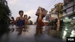 Warga Bangkok bergerak melalui jalanan yang terendam banjir. Banjir di Thailand yang sudah mulai sejak bulan Juli merupakan bencana terburuk selama 50 tahun terakhir di negara itu (foto:dok).