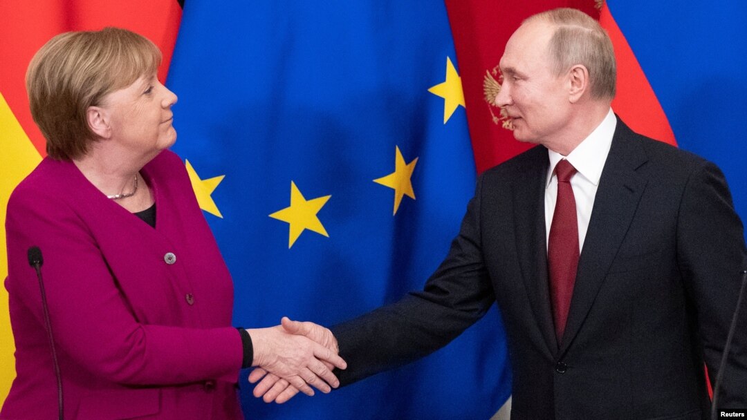 Presiden Rusia Vladimir Putin dan Kanselir Jerman Angela Merkel berjabat tangan setelah konferensi pers bersama di Kremlin, Moskow, Rusia, 11 Januari 2020. 