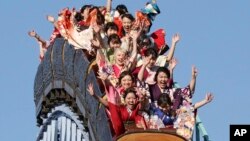 Para perempuan berkimono merayakan ulang tahun ke-20 mereka dengan menaiki sebuah roller coaster di Taman Hiburan Toshimaen, Tokyo, Senin 14 Januari 2019. (Foto: AP/Koji Sasahara)