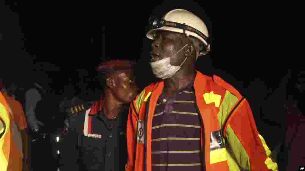 Jami'an 'yansanda da ma'aikatan ceto da masu wucewa duk suka taru kusa da ginin da ake ginawa wanda ya rushe a Legas hudu ga watan Nuwamba shekarar 2013.