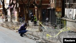 A police officer investigates the scene of a deadly blaze, in Johannesburg, South Africa, September 1, 2023.