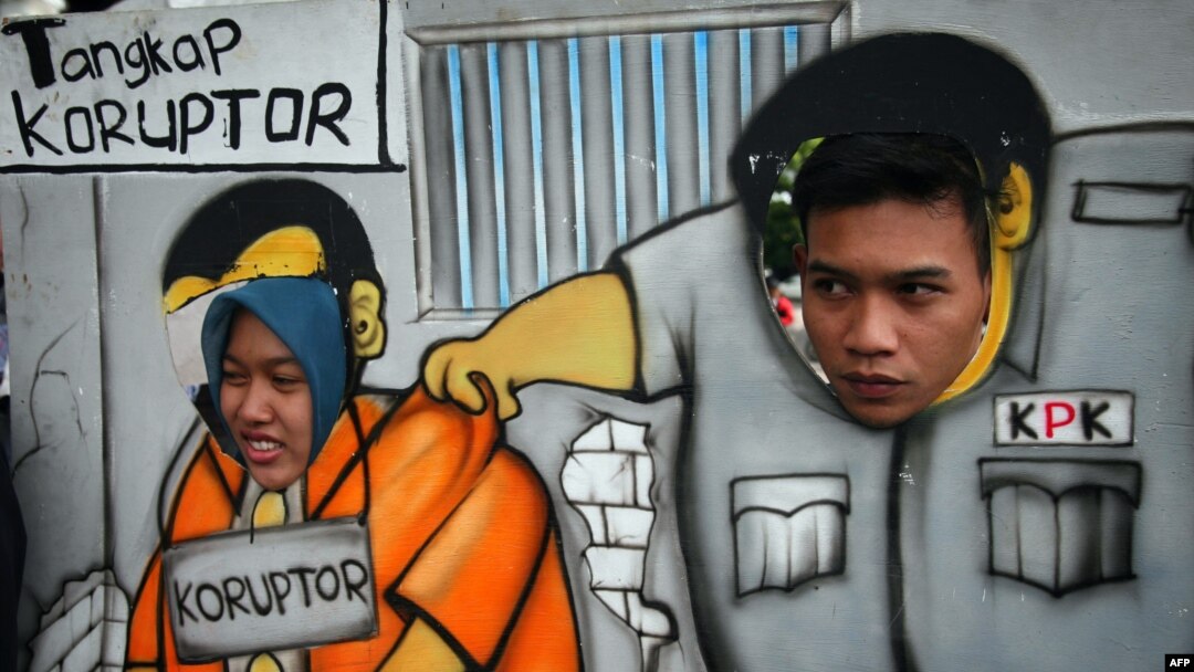 Para pendukung KPK berpawai dengan menggunakan kardus bergambar petugas KPK menangkap koruptor di Malang, Jawa Timur, 23 Januari 2015. (Foto: AFP)