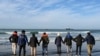 Sejumlah imigran tengah menunggu kapal penyelundup yang akan membawa mereka menyeberangi Selat Inggris di pantai Audresselles di utara Prancis, pada 25 Oktober 2024. (Foto: AFP/Bernard Barron)