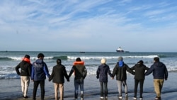 Sejumlah imigran tengah menunggu kapal penyelundup yang akan membawa mereka menyeberangi Selat Inggris di pantai Audresselles di utara Prancis, pada 25 Oktober 2024. (Foto: AFP/Bernard Barron)