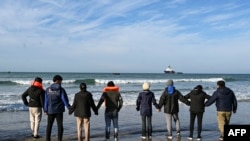 Sejumlah imigran tengah menunggu kapal penyelundup yang akan membawa mereka menyeberangi Selat Inggris di pantai Audresselles di utara Prancis, pada 25 Oktober 2024. (Foto: AFP/Bernard Barron)