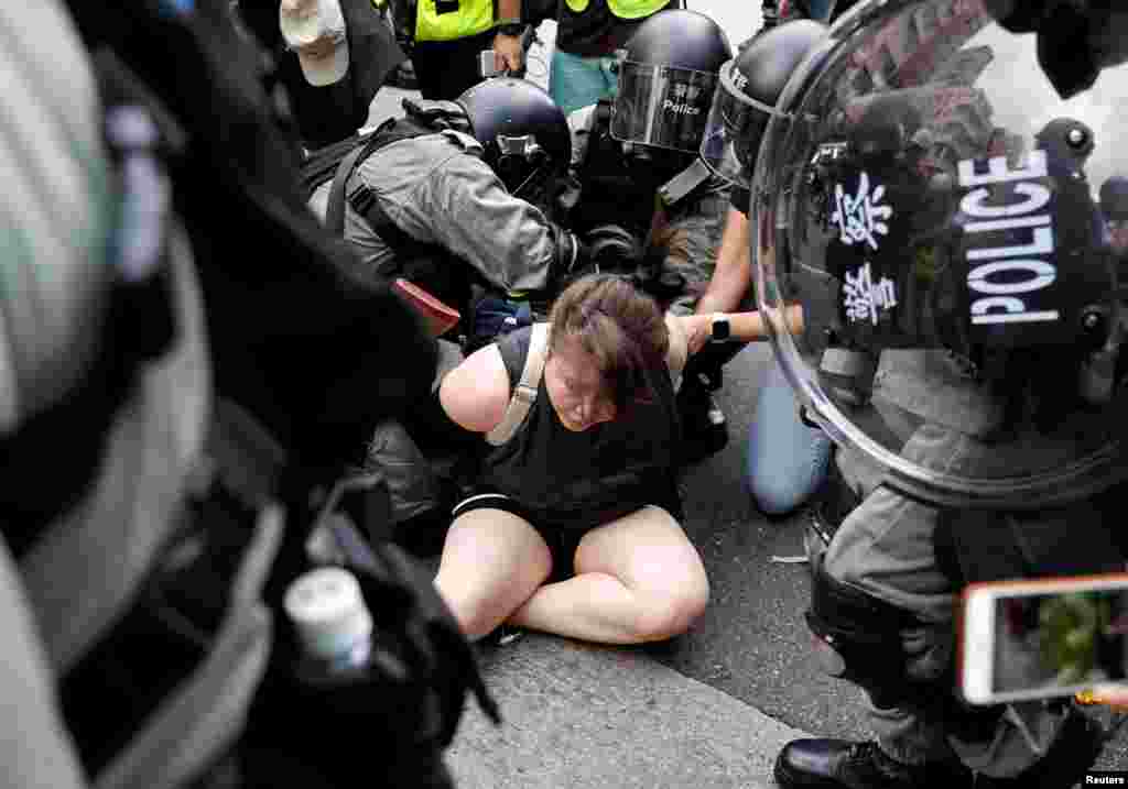 Manifestantes aseguran que luchan contra lo que consideran la erosión del acuerdo conocido como “un país, dos sistemas” que sobre el papel garantizaba una cierta autonomía de Hong Kong desde que China retomara la isla del control británico en 1997. En la foto, agentes de la policía antidisturbios detienen a un manifestante contra el proyecto de ley de extradición durante una marcha en el barrio de Sham Shui Po en Hong Kong, China, el 11 de agosto de 2019.