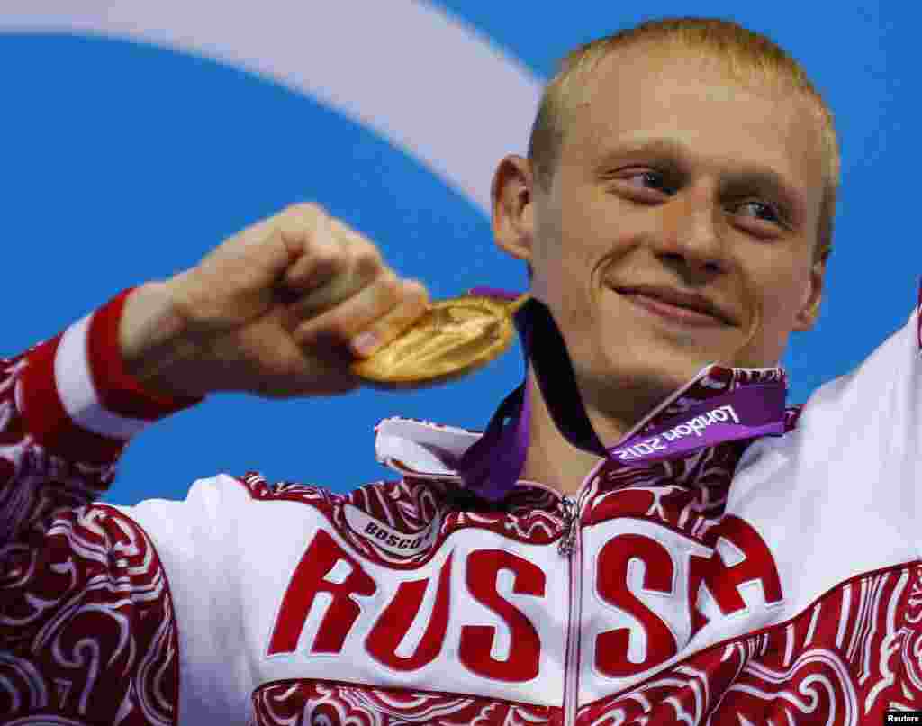 Russia's Ilya Zakharov poses with his gold medal on the podium after winning the men's 3m springboard final at the London 2012 Olympic Games at the Aquatics Centre August 7, 2012