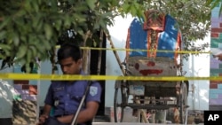 Seorang polisi berdiri di samping becak yang dilaporkan ditumpangi oleh warga Jepang Kunio Hoshi ketika ia dibunuh di desa Mahiganj di distrik Rangpur, 300 km sebelah utara Dhaka, Bangladesh, Minggu, 4 Oktober 2015.