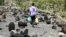 FILE - A boy walks on a street littered with cooking gas cylinders after a fire and explosions destroyed a nearby gas storage during clashes between fighters of the Popular Resistance Committees and Houthi fighters, in Yemen's southwestern city of Taiz, July 19, 2015.