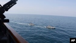 Kapal Garda Revolusioner Iran berlayar dekat kapal-kapal militer AS di Teluk Persia dekat Kuwait, 15 April 2020.