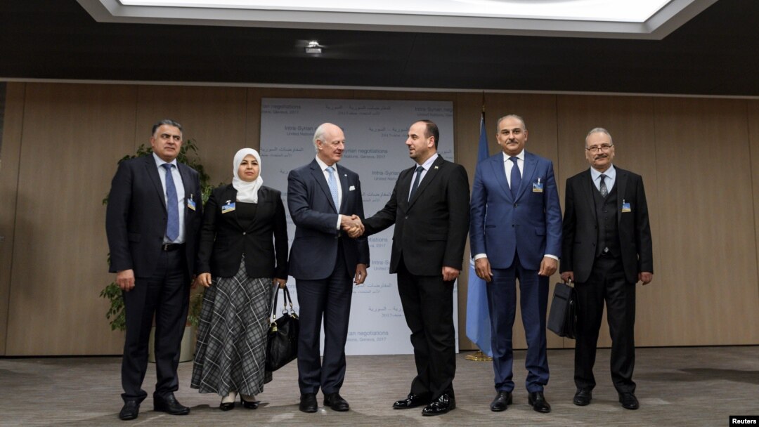 Utusan Khusus PBB untuk Suriah, Staffan de Mistura (tiga dari kiri), menjabat tangan Kepala Komisi Negosiasi Suriah, Nasr al-Hariri, (tiga dari kanan), disamping anggota delegasi kelompok oposisi Khaled al-Mahamid, Hanadi Abu Arab, Jamal Suliman and Safwan Akash, pada pembukaan putaran pembicaraan damai Suriah yang baru di kantor PBB, Jenewa, Swiss, 28 November 2017.