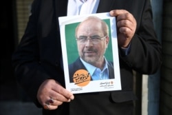 A man holds a poster of Mohammad Baqer Qalibaf one of parliamentary candidate in Tehran, Iran, Feb. 18, 2020.