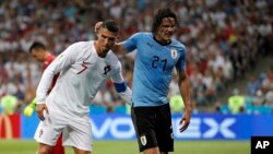 Cristiano Ronaldo, à gauche, aide Edinson Cavani à quitter le terrain après sa blessure, Russie, le 30 juin 2018 