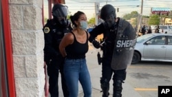 FILE - Police officers are shown arresting Des Moines Register reporter Andrea Sahouri after a Black Lives Matter protest she was covering on May 31, 2020, in Des Moines, Iowa, was dispersed by tear gas. (Photo courtesy Katie Akin via AP)