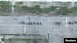 无人机拍摄的图像显示乌军伤员躺在担架上被抬出马里乌波尔的亚速钢铁厂。(2022年5月17日)