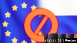 FILE PHOTO: Illustration shows Models of oil barrels in front of sign "stop", EU and Russia flag colours