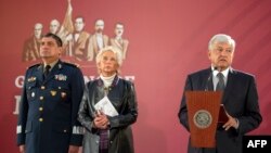 FILE - Mexican President Andres Manuel Lopez Obrador, flanked by Secretary of Defense Luis Cresencio Sandoval (L) and Interior Minister Olga Sanchez Cordero, gives a press conference at the National Palace in Mexico City, Dec. 3, 2018.