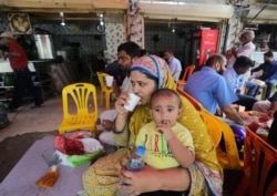 People eat at a restaurant following an ease in restrictions that had been imposed to help control the coronavirus, in Karachi, Pakistan, Aug. 10, 2020.