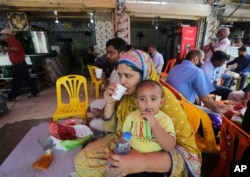 People eat at a restaurant following an ease in restrictions that had been imposed to help control the coronavirus, in Karachi, Pakistan, Aug. 10, 2020.
