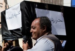 FILE - Journalists carry a symbolic coffin representing what they say "journalism freedom," at the Journalists' Syndicate in Cairo, Egypt, November 23, 2016.