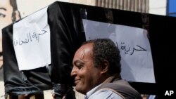 FILE - Journalists carry a symbolic coffin representing what they say "journalism freedom," at the Journalists' Syndicate in Cairo, Egypt, Nov. 23, 2016. 