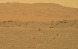 In this image from NASA, NASA's experimental Mars helicopter Ingenuity lands on the surface of Mars, April 19, 2021.