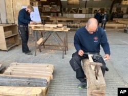 Carpenters work on pieces, part of the new roof for the Notre Dame de Paris cathedral on May, 25, 2023, near Angers, western France. (AP Photo/Jeffrey Schaeffer)