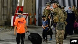 22일 아프가니스탄 카불 국제공항에서 미군들이 탈레반 점령을 피해 아프가니스탄을 탈출하는 사람들을 지원하고 있다.