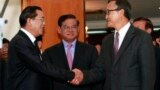 Cambodian Prime Minister Hun Sen, left, shakes hands with opposition party leader Sam Rainsy, right, after a meeting, as Sar Kheng, center, deputy prime minister, looks on at the National Assembly in Phnom Penh, Cambodia, Monday, Sept. 16, 2013.