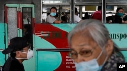People ride a bus during the first day of a more relaxed lockdown that was placed to prevent the spread of the new coronavirus in Manila, Philippines on Monday, June 1, 2020. Traffic jams and crowds of commuters are back in the Philippine capital,…