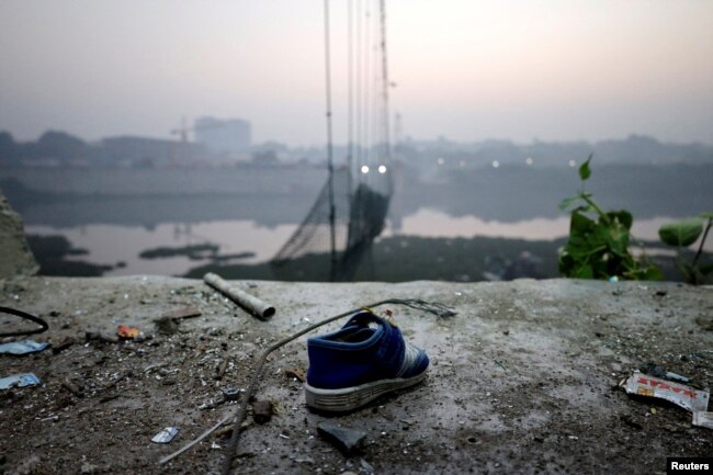 A shoe lies near a damaged suspension bridge after it collapsed on Sunday, in Morbi town in the western state of Gujarat, India, Nov. 1, 2022.